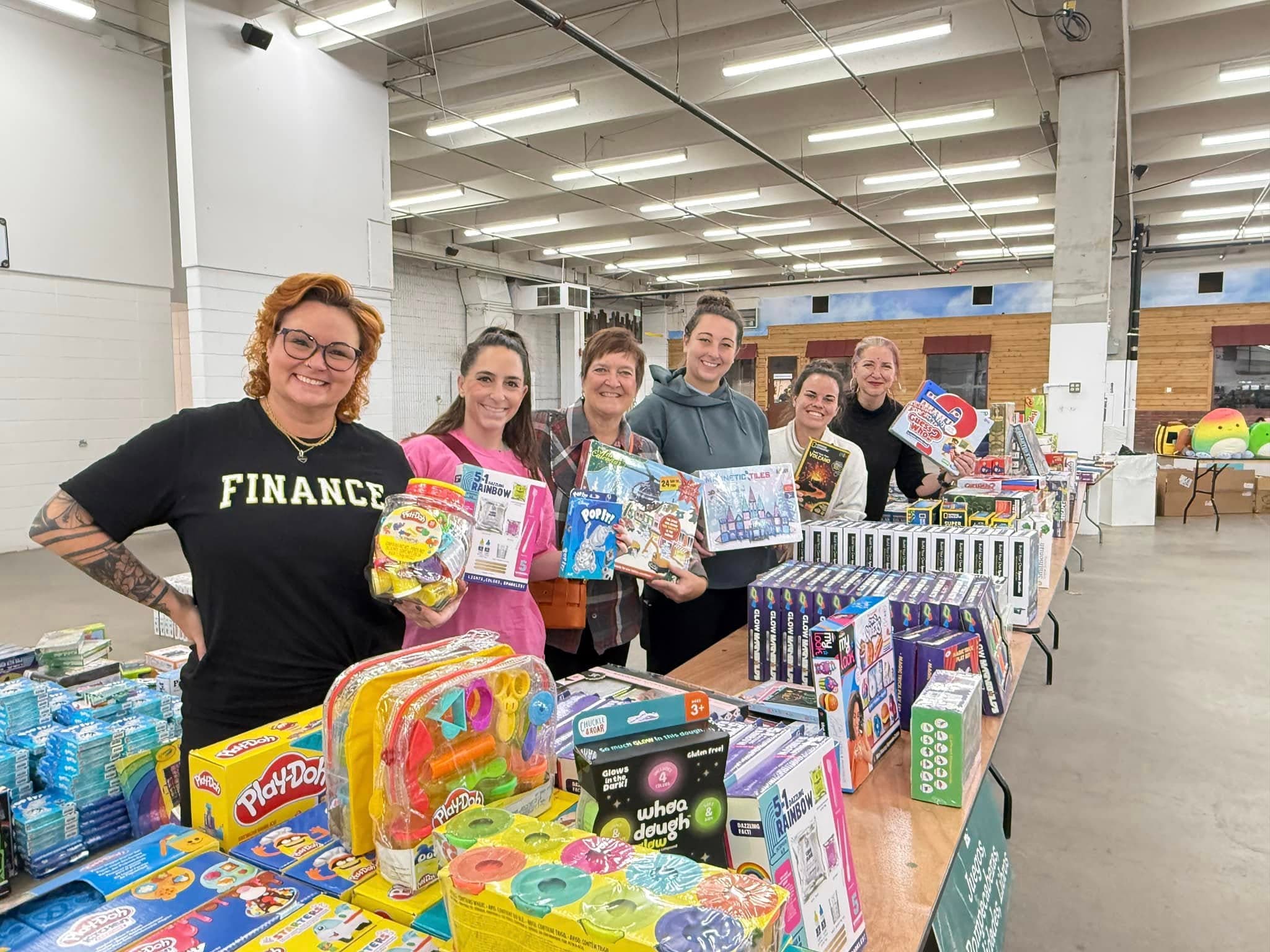 Kenzi's Causes Toy Shop volunteers with tables full of toys