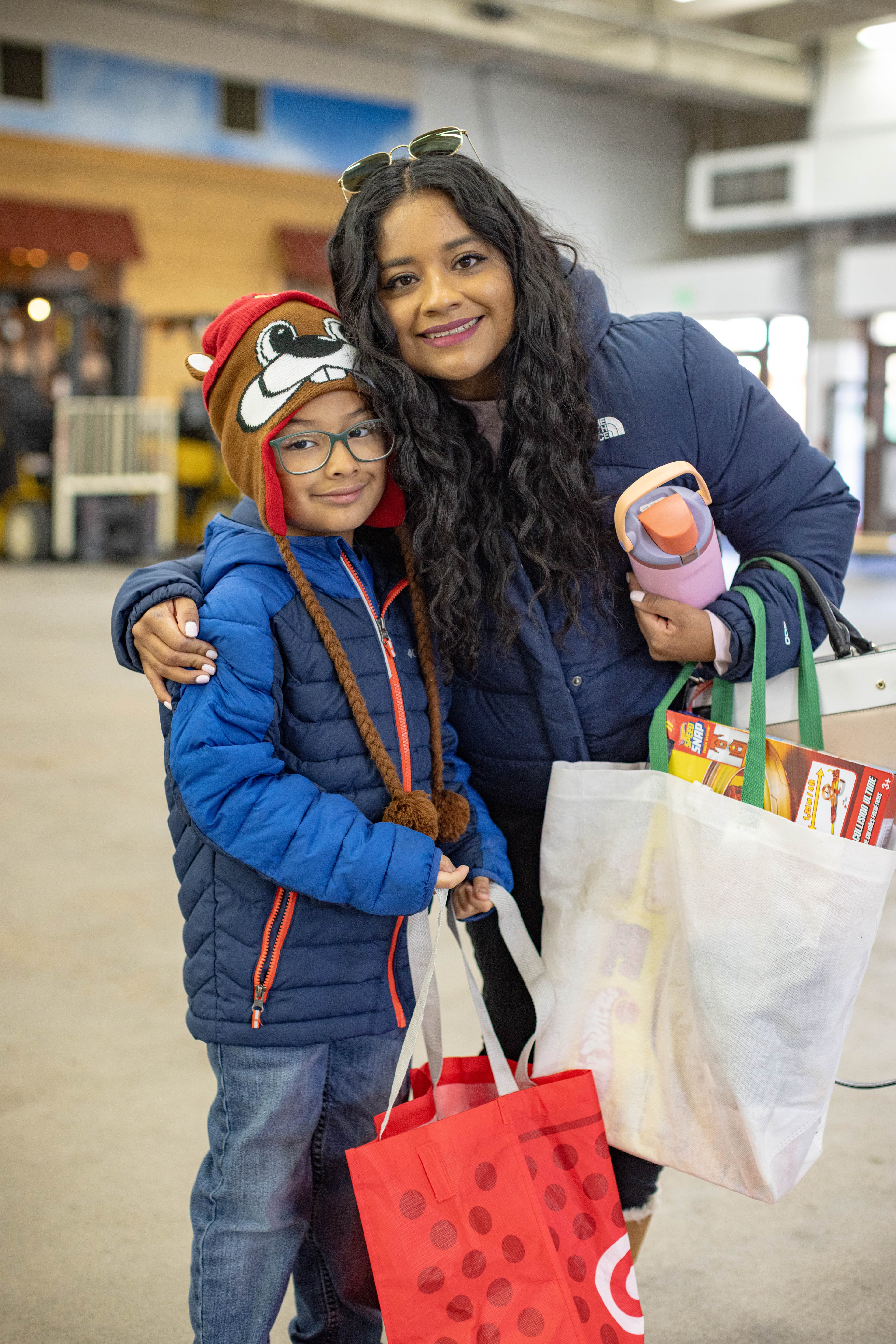 A mom and son leaving the Toy Shop with their gifts