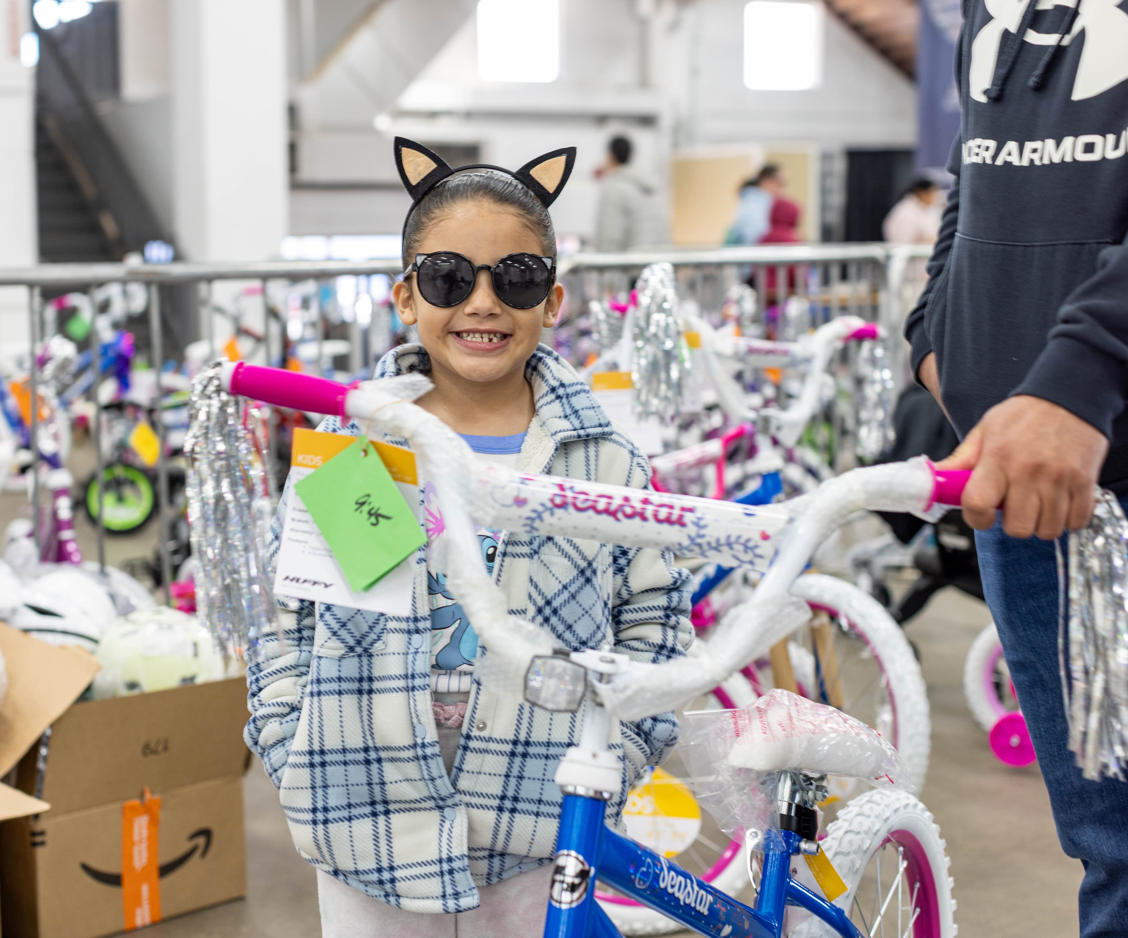 A girl beaming with her new bike at the Kenzi's Causes Toy Shop