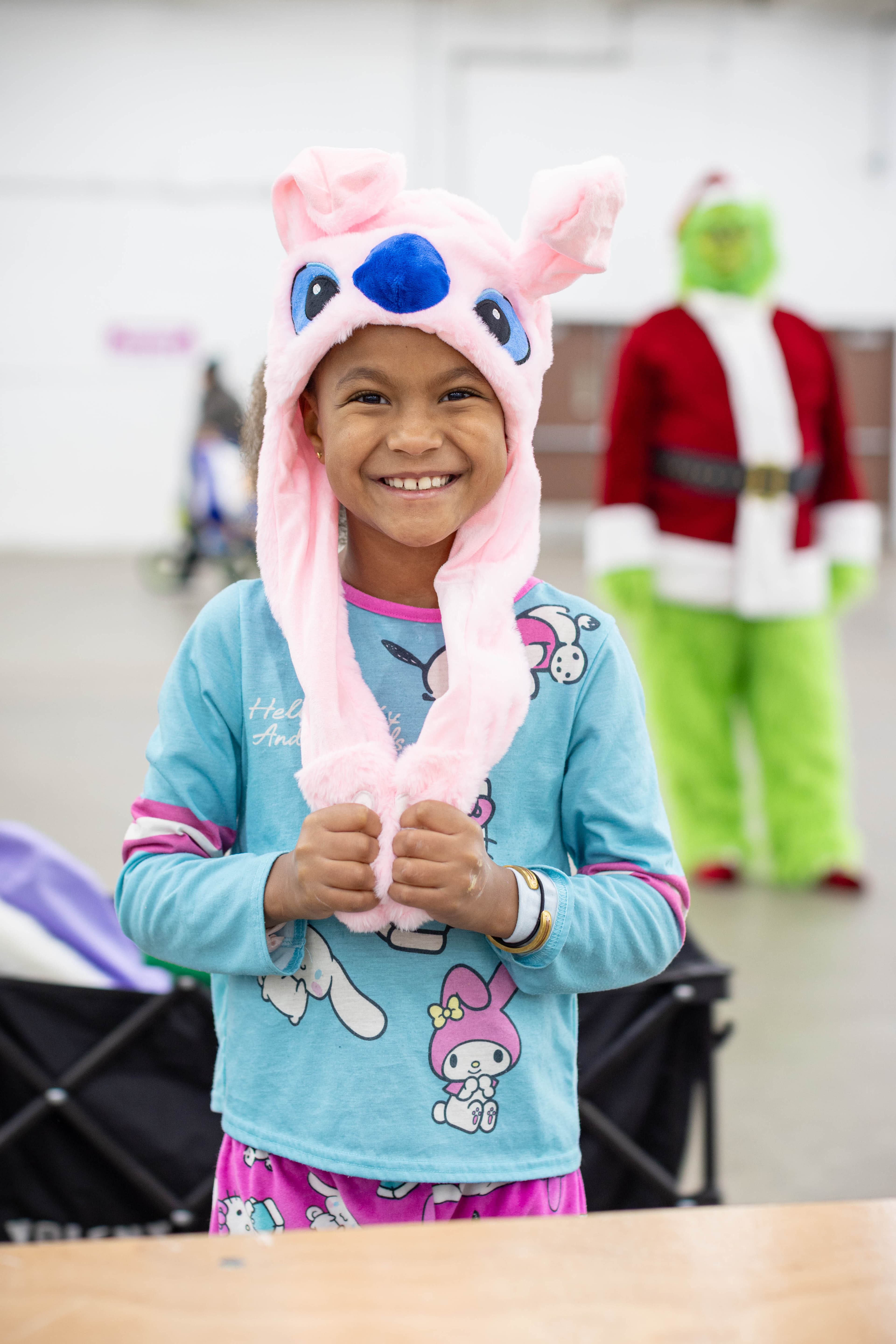 A girl in a festive Stitch hat celebrating at the Toy Shop